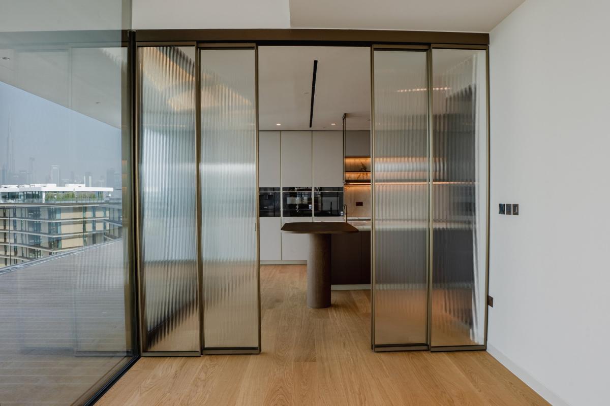 Kitchen seen through a fluted glass sliding door, Bulgari Penthouse Building, Bulgari Island, Dubai