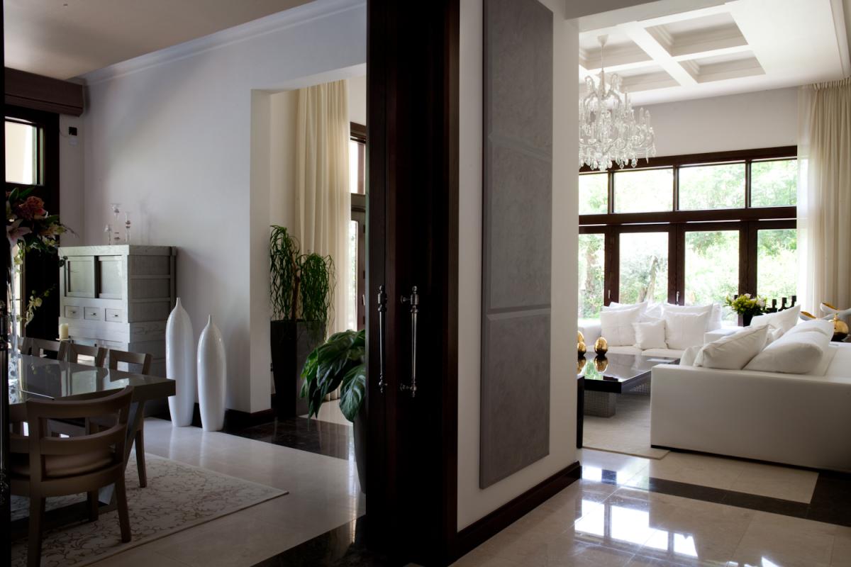 Open-plan living and dining area with dark wood accents and a marble floor, Al Barari Villa, Al Barari, Dubai