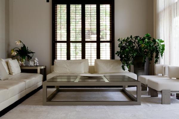 Living room with white sofas, a glass and wood coffee table, and arched windows, Al Barari Villa, Al Barari, Dubai