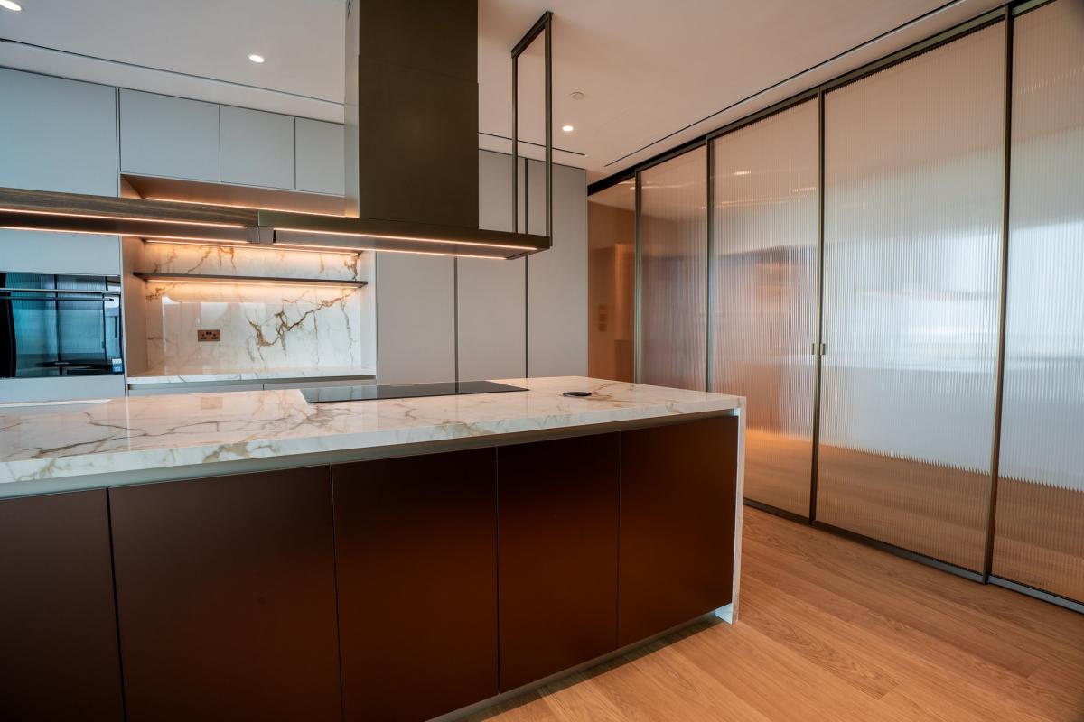 Kitchen with a dark wood island and a marble countertop, Bulgari Penthouse Building, Bulgari Island, Dubai