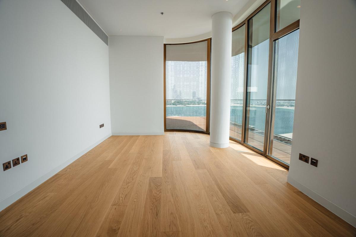Empty room with a curved wall of windows and wood flooring, Bulgari Penthouse Building, Bulgari Island, Dubai