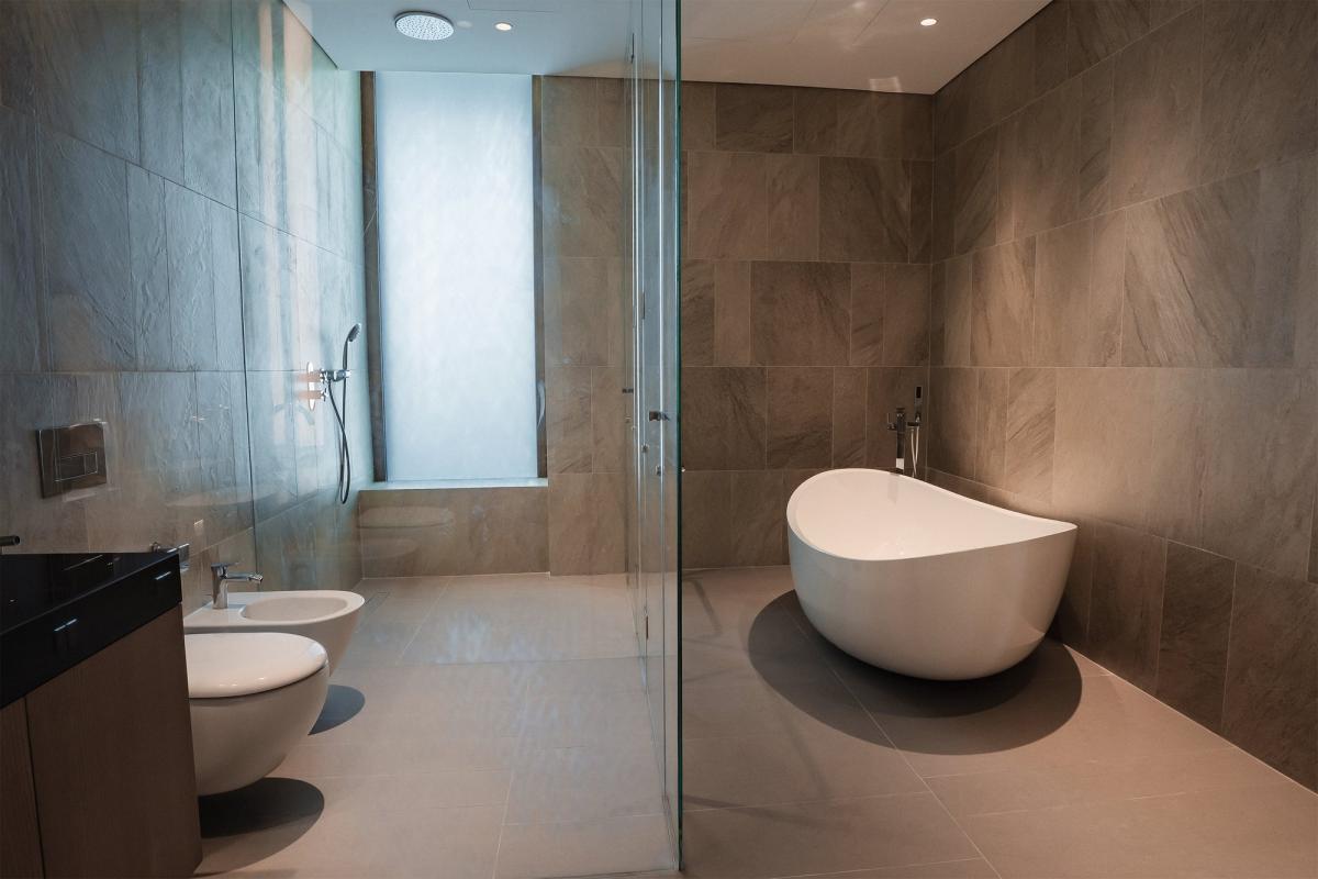 Bathroom with a freestanding tub, twin sinks, and stone tile walls, Bulgari Penthouse Building, Bulgari Island, Dubai