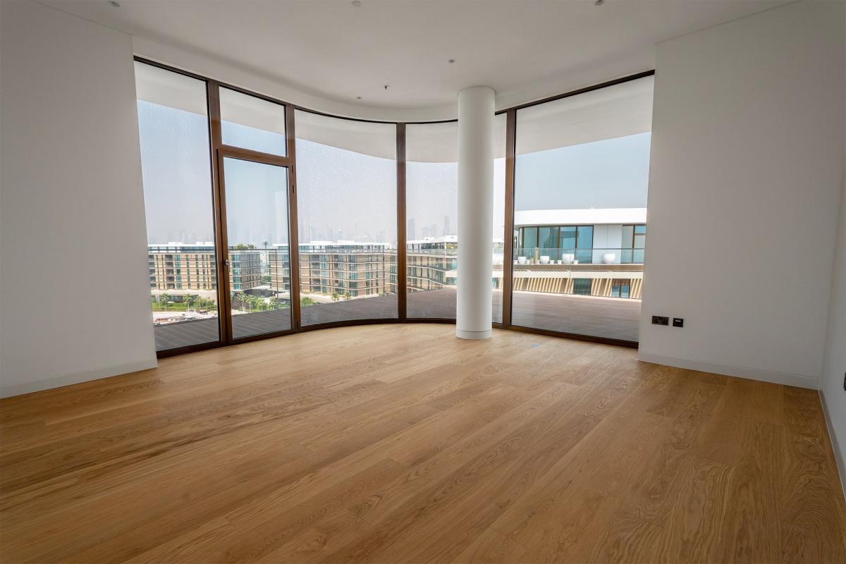 Empty curved room with floor-to-ceiling windows and wood flooring, Bulgari Penthouse Building, Bulgari Island, Dubai