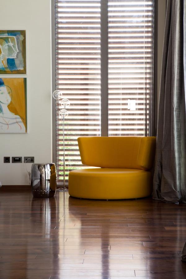 Corner with a mustard-yellow curved swivel chair and an abstract art print, Emirates Hills Villa, Emirates Hills, Dubai