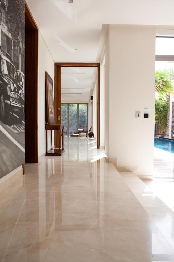 Hallway with framed art and marble flooring leading to a pool view, Emirates Hills Villa, Emirates Hills, Dubai