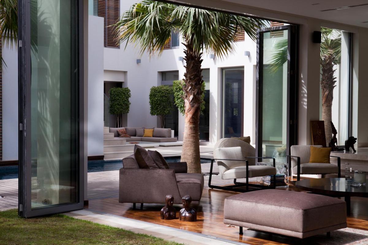 Courtyard with palm trees and open glass doors to an outdoor lounge area, Emirates Hills Villa, Emirates Hills, Dubai
