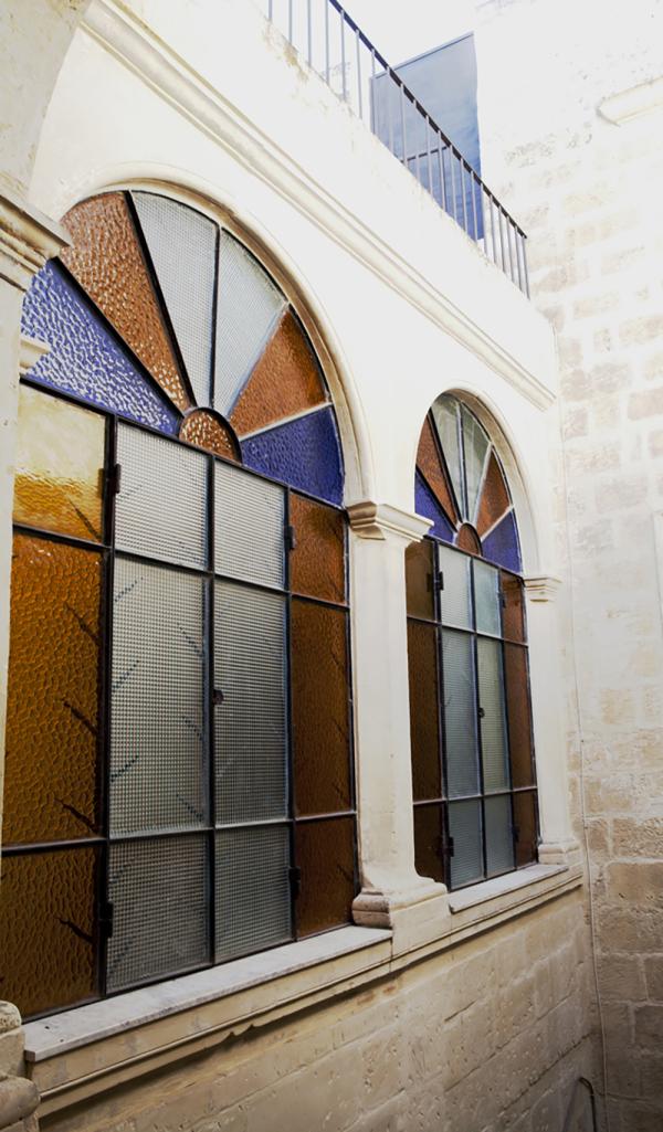 Stained glass arched window with a wrought iron grille, Historical Apartment in Puglia, Lecce, Puglia