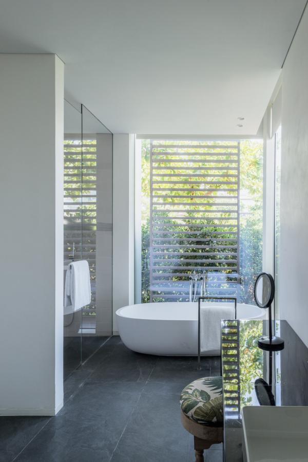 Bathroom with a freestanding tub and slatted timber window screen, Oberoi Resort, Ajman