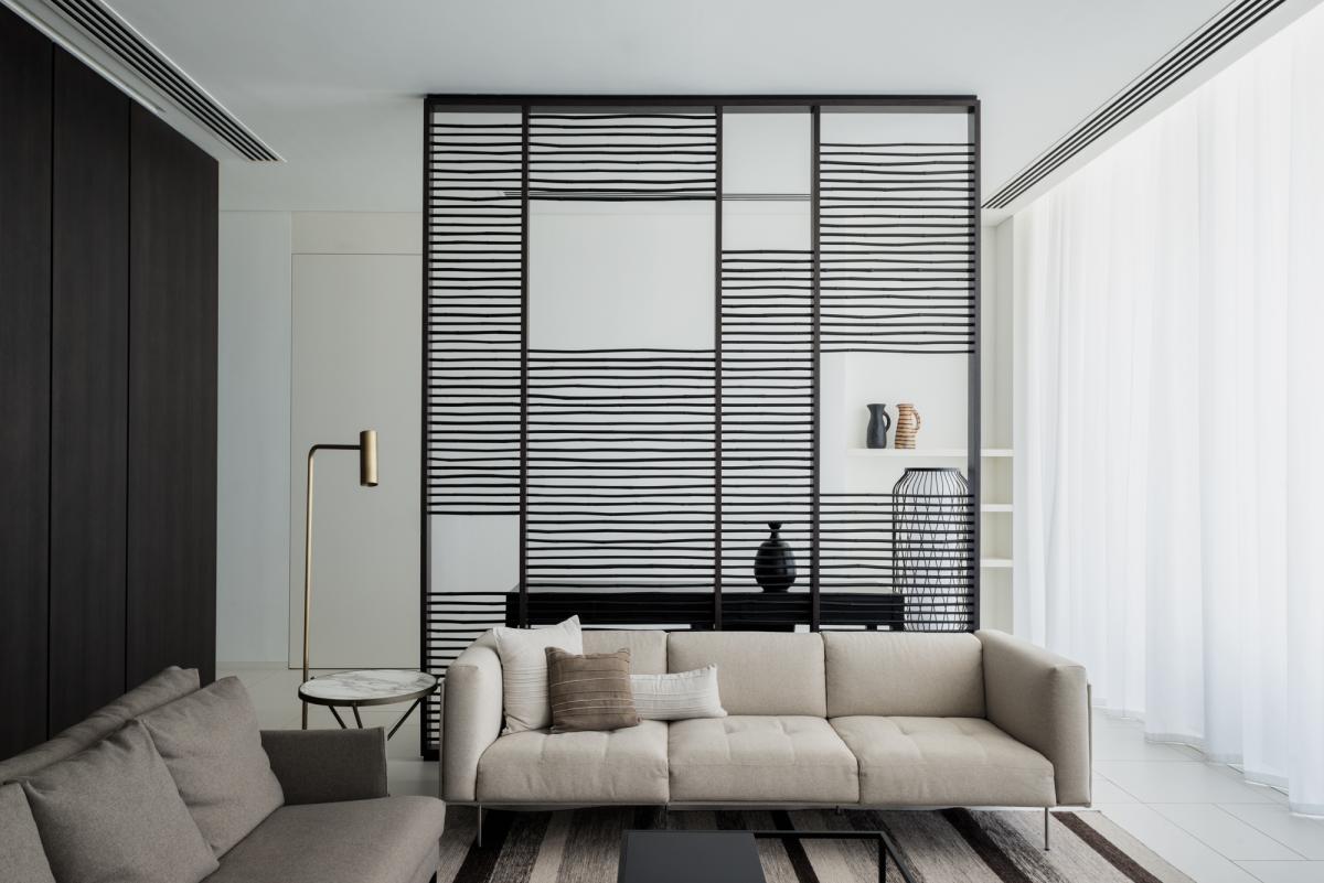 Suite lounge with a dark screen partition and beige sofa, Oberoi Resort, Ajman