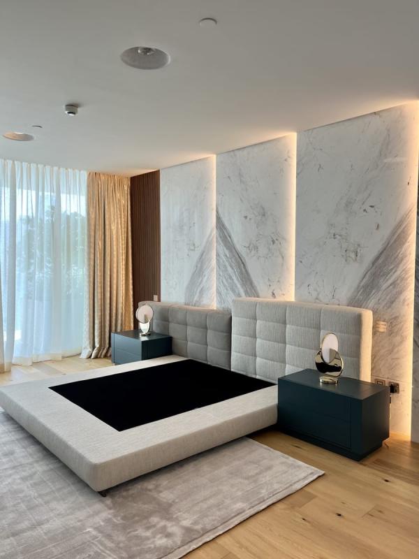 Bedroom with a grey upholstered headboard and a marble accent wall, One at Palm, Four Bedrooms, Palm Jumeirah, Dubai