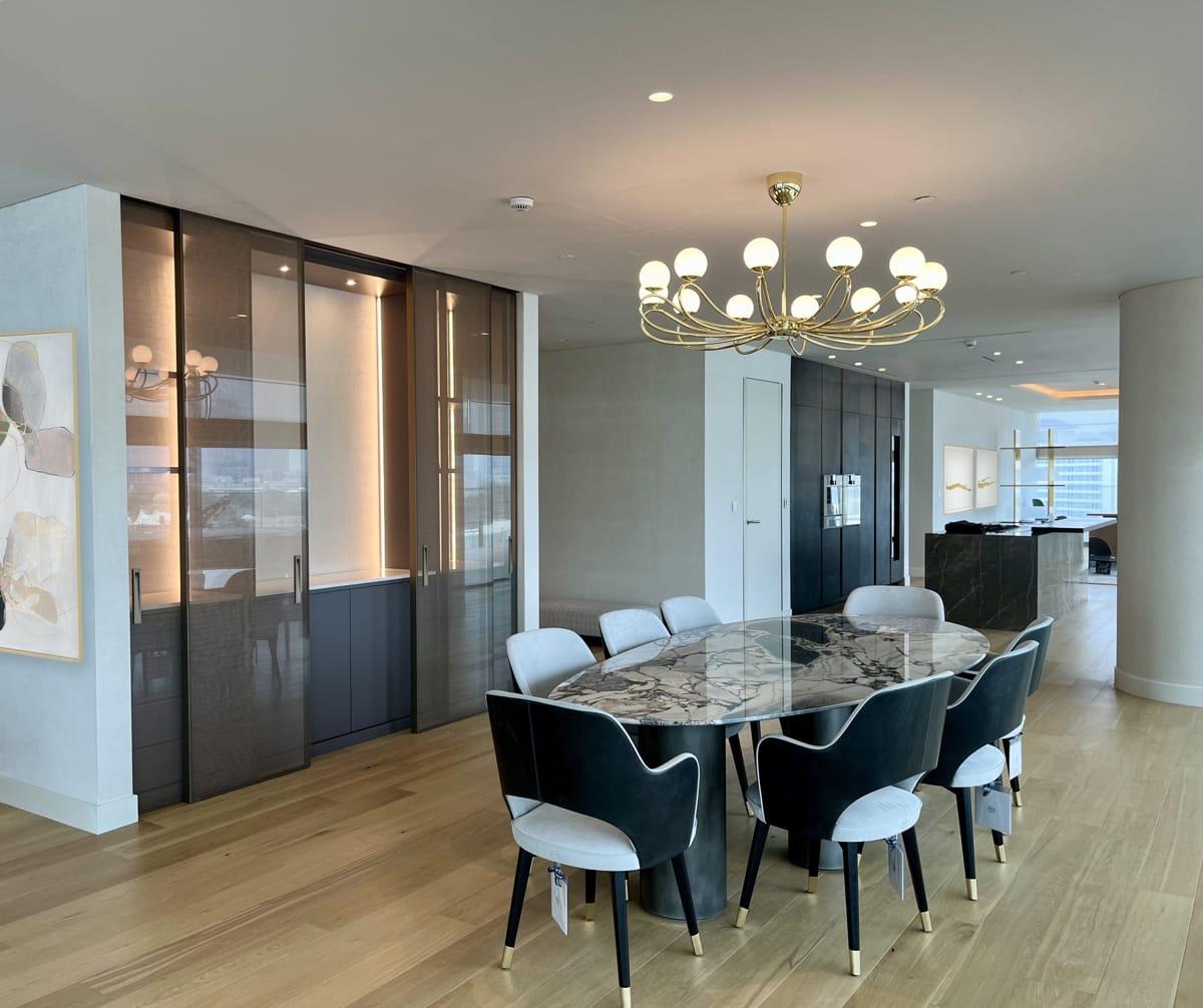 Dining room with a marble table, dark upholstered chairs, and a crystal chandelier, One at Palm, Four Bedrooms, Palm Jumeirah, Dubai