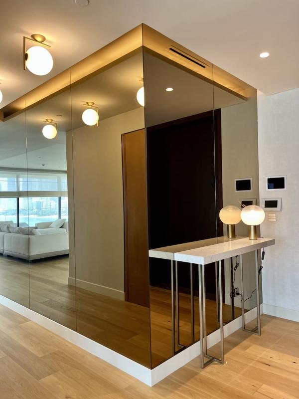 Open-plan living area seen through a mirrored partition with a marble-topped bar, One at Palm, Four Bedrooms, Palm Jumeirah, Dubai