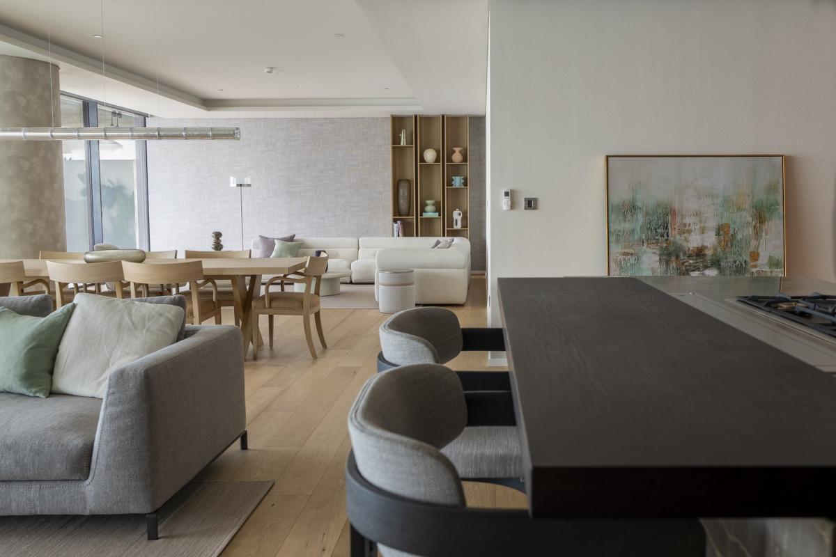 Open-plan living, dining, and kitchen area with grey seating and a dark island, One at Palm, Three Bedrooms (Central Wing), Palm Jumeirah, Dubai