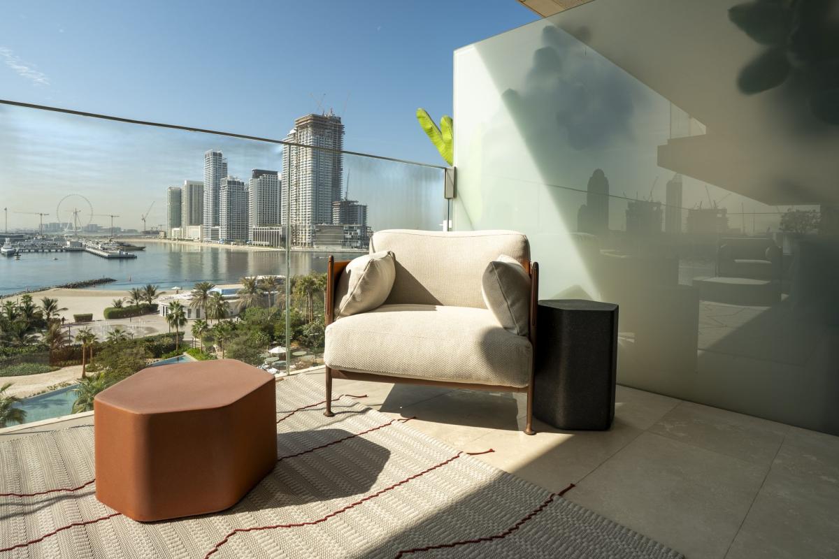 Living room corner with a boucle armchair, a bronze side table, and a marina view, One at Palm, Three Bedrooms (Central Wing), Palm Jumeirah, Dubai