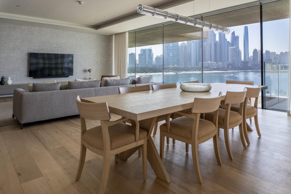 Dining area with a wood table and wicker chairs facing a skyline view, One at Palm, Three Bedrooms (Central Wing), Palm Jumeirah, Dubai