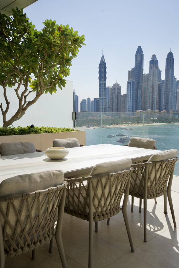 Terrace dining table with sea and skyline view, One at Palm Three Bedrooms, Palm Jumeirah