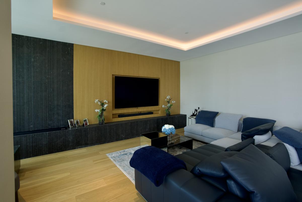 Living room with a textured dark accent wall and blue sofas, One at Palm Three Bedrooms, Palm Jumeirah