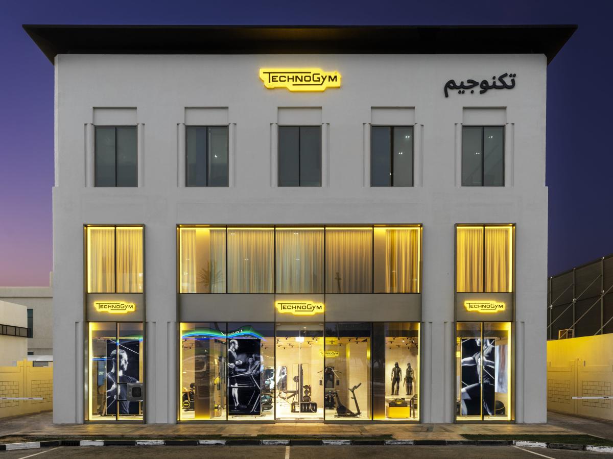 Building facade at night with illuminated storefront signage, Technogym Headquarters, Dubai