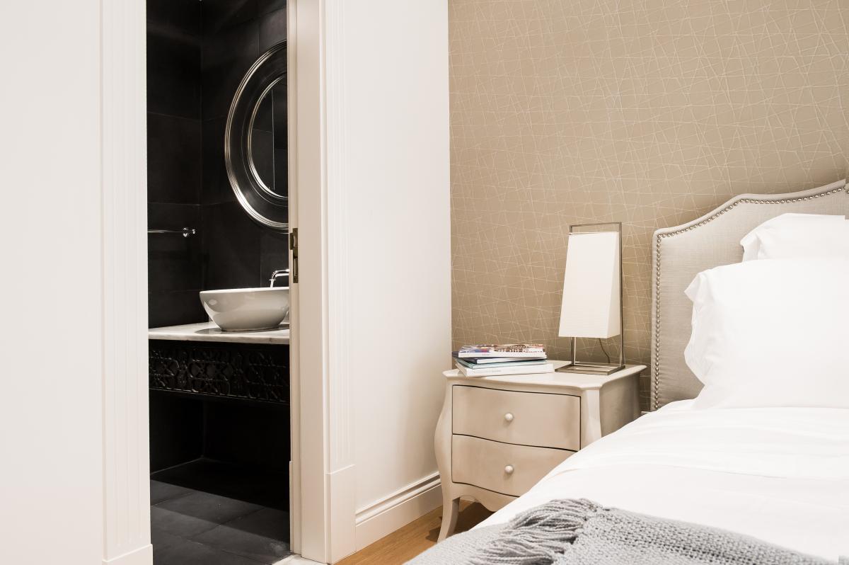 Bedroom with an ensuite bathroom seen through an open door and a round mirror, Zabeel Saray Resort Villa, Palm Jumeirah, Dubai