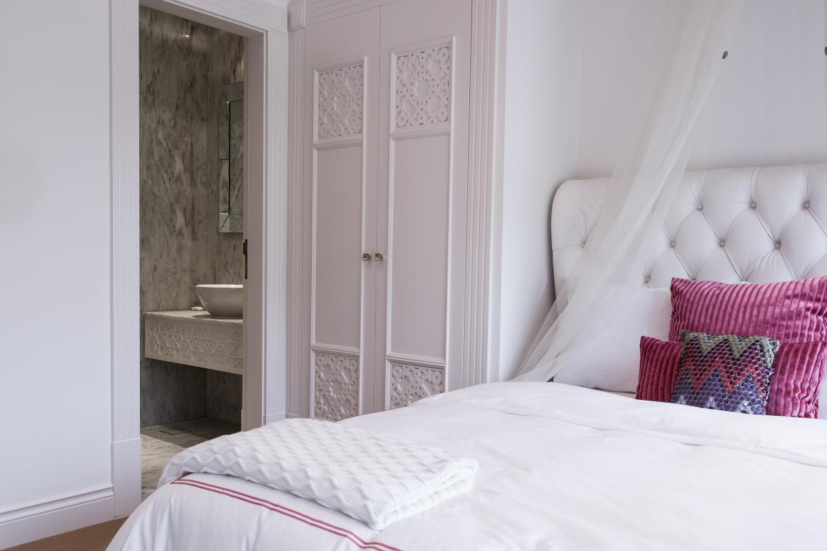 Bedroom with a tufted white headboard, a sheer canopy, and patterned accent pillows, Zabeel Saray Resort Villa, Palm Jumeirah, Dubai