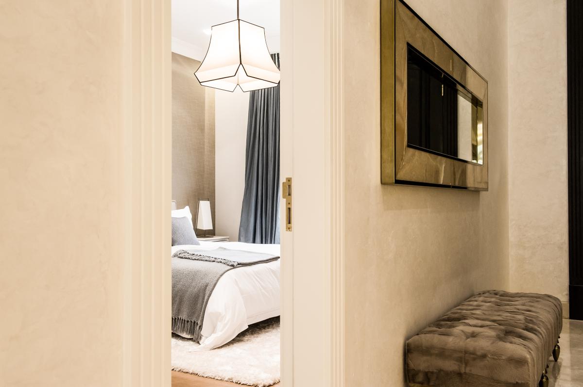 Bedroom with a gold-framed mirror and a velvet bench at the foot of the bed, Zabeel Saray Resort Villa, Palm Jumeirah, Dubai